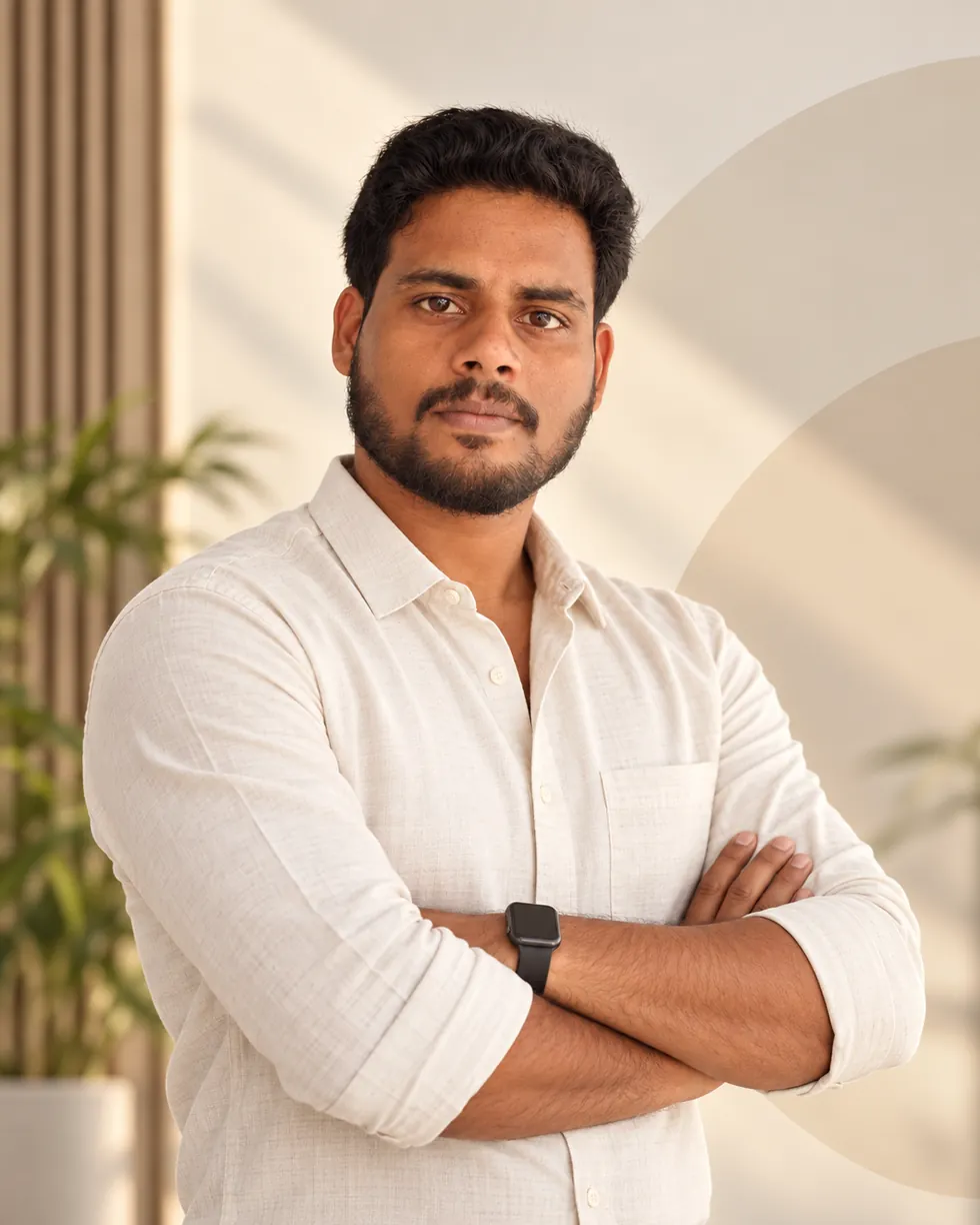 Portrait of Kishor Sivakumar with folded arms in a light shirt